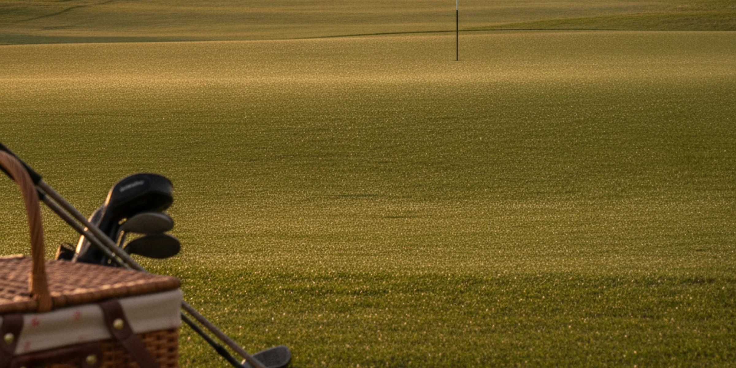 A golf green at golden hour with the flag in.